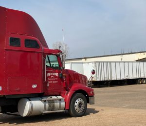 red Master Trucking semi truck pulling into warehouse ready to load shipment of fibre barrels at The Master Package Fibre Shipping Containers